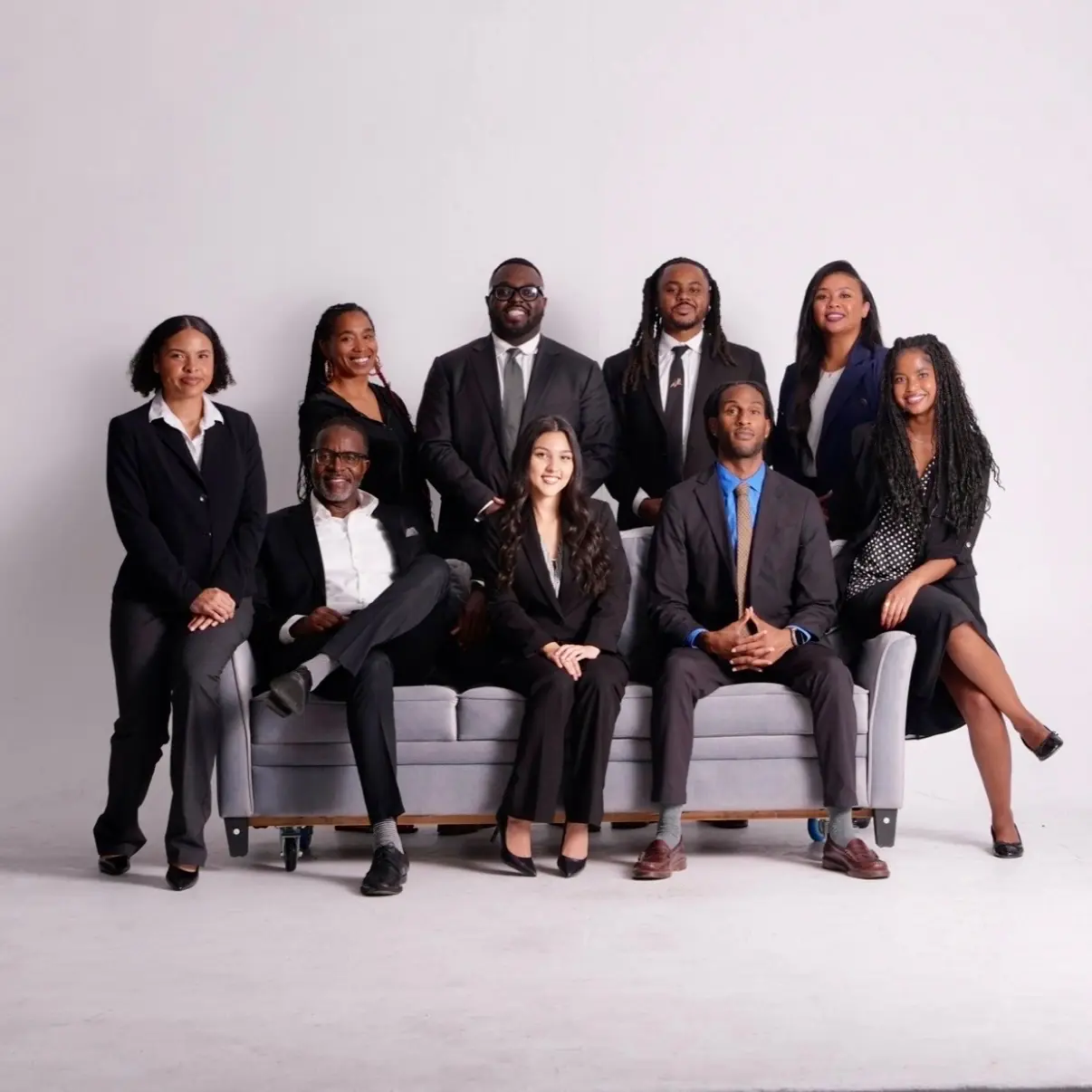 The Grace Legal Group team on a couch in suits